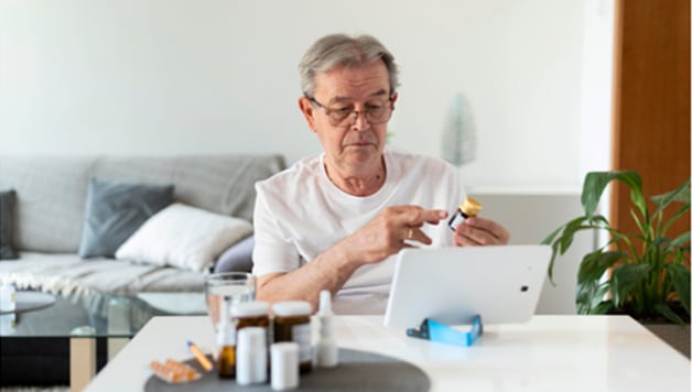 Old man taking medicines as a Parkinson’s management measure after diagnosis.